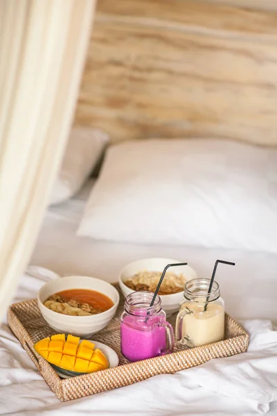 Gezonde rauw Fruit Ontbijt op Bed. Kleur Smoothie op rieten Tra — Stockfoto