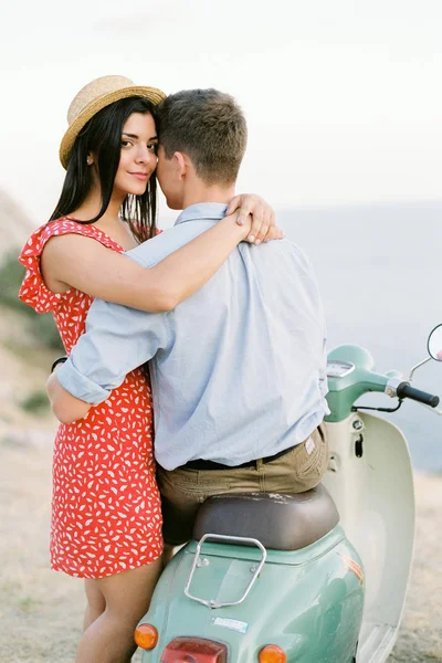 Happy young couple in love on retro motorbike driving togetger and ejoying the trip near the ocean. — Stock Photo, Image