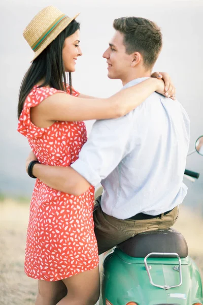 Happy young couple in love on retro motorbike driving togetger and ejoying the trip near the ocean. — Stock Photo, Image