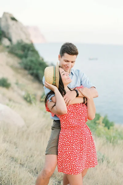 Unga snygga par i kärlek promenader i bergen vid havet. Vine solnedgång sommar humör — Stockfoto