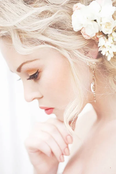 Όμορφη μελαχρινή νύφη κοντά ένα ανθίζοντας θάμνο τριαντάφυλλα θέτοντας σε ένα γαμήλιο φόρεμα — Φωτογραφία Αρχείου