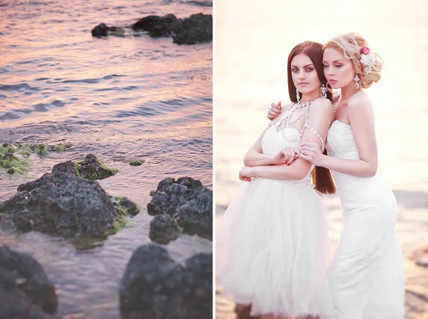 Jovens duas noivas em vestidos brancos Posando junto ao mar ao pôr-do-sol — Fotografia de Stock