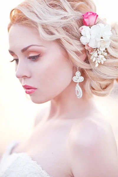 Giovane bruna sposa in abito bianco in posa al mare al tramonto — Foto Stock