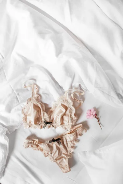 Vackra siden underkläder underkläder ligger på en vit säng — Stockfoto