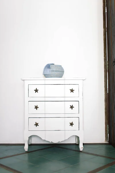 White vintage chest of drawers stands near white wall — Stock Photo, Image