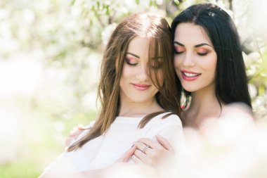 İki güzel kız bir çiçek bahçesinde standı, aptal oyun ve