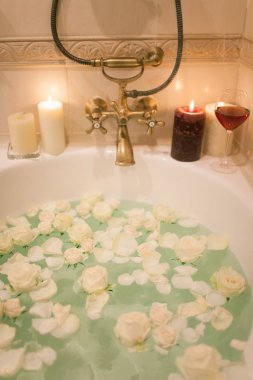 Gül yaprakları ve mum banyo. Romantik akşam TH