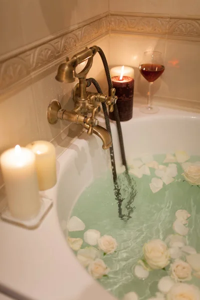 Tome un baño con pétalos de rosa y velas. Noche romántica en th —  Fotos de Stock