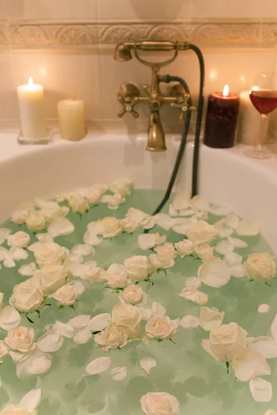 Tome un baño con pétalos de rosa y velas. Noche romántica en th — Foto de Stock