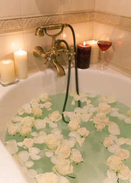 Tome un baño con pétalos de rosa y velas. Noche romántica en th —  Fotos de Stock