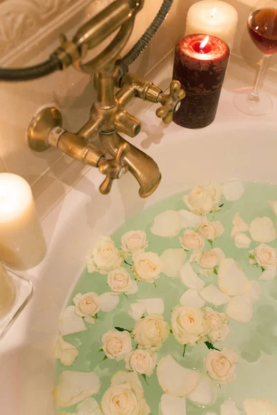 Tome un baño con pétalos de rosa y velas. Noche romántica en th —  Fotos de Stock