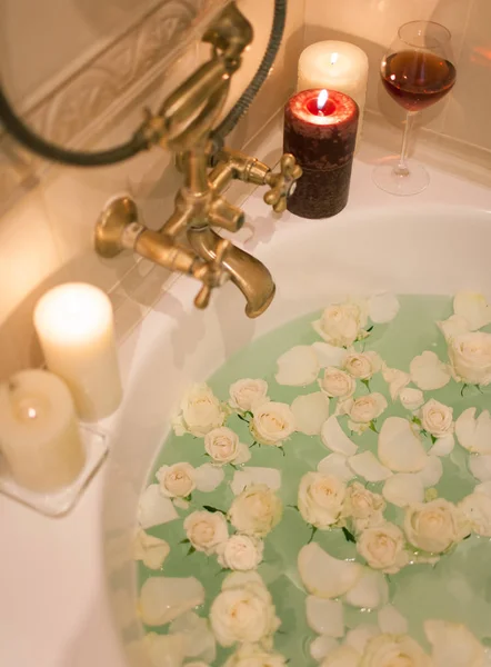 Kąpieli z płatkami róż i świece. Romantyczny wieczór w th — Zdjęcie stockowe