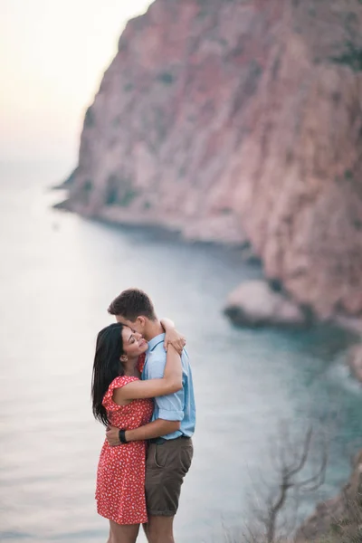 Unga snygga par i kärlek promenader i bergen vid havet. Vine solnedgång sommar humör — Stockfoto