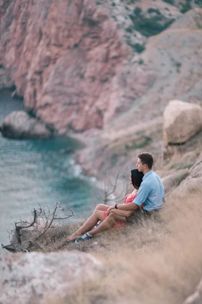 Deniz tarafından dağlarda yürüyüş aşık genç şık çift. Asma günbatımı yaz ruh hali — Stok fotoğraf