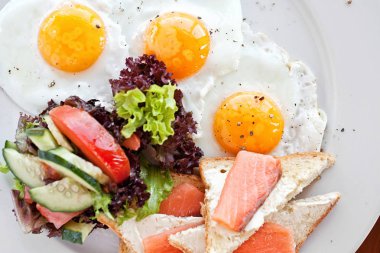 Amerikan kahvaltısı ile kızarmış yumurta, somon, tost, kızarmış balık.