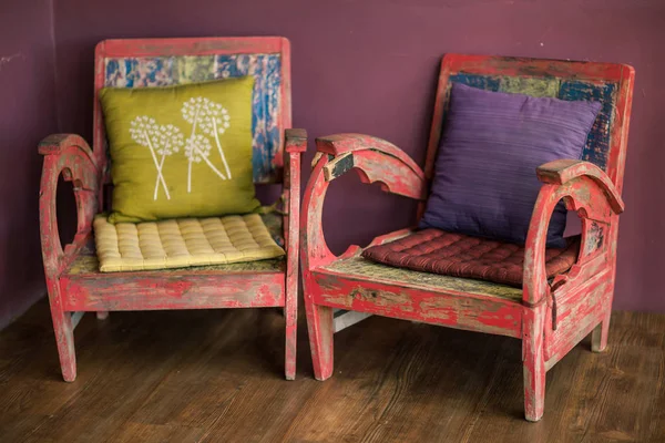 Старый старинный деревянный стул стоит у цветной стены — стоковое фото