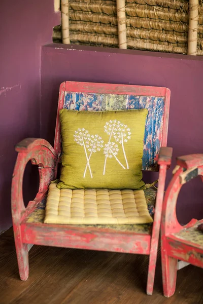 Старый старинный деревянный стул стоит у цветной стены — стоковое фото