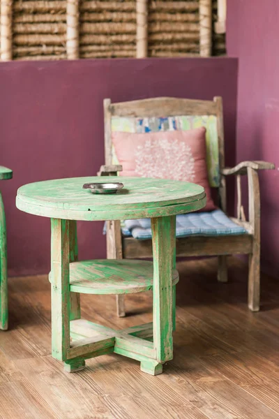 Stare drewniane krzesło vintage stoi w pobliżu kolorowe ściany — Zdjęcie stockowe