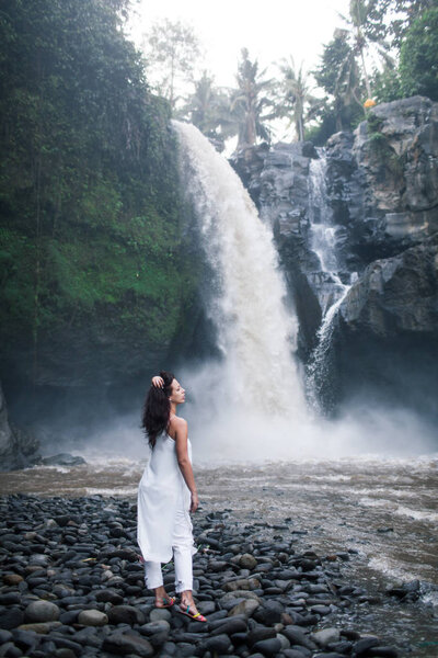 Young Girl in White Clothes Walking near a Waterfall Tegenungan 