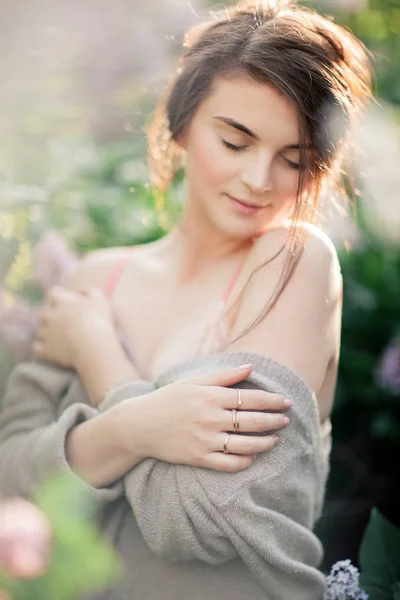 Giovane ragazza in pizzo reggiseno Posa in fiore lilla. Canzoni del tramonto. Tenero umore — Foto Stock