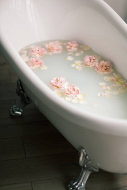 Süt ve gül yaprakları ile beyaz banyo. Gevşeme ve uyum