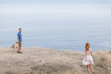 İki adam dağda Okyanusu yakın onların köpekle oynamayı