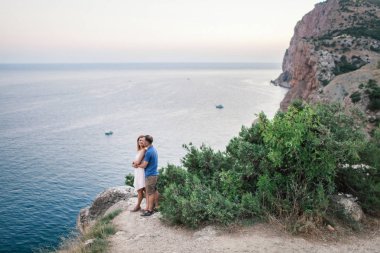 İki adam dağda Okyanusu yakın onların köpekle oynamayı