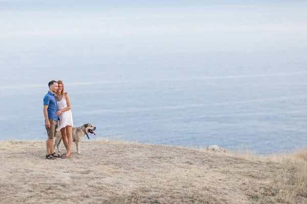 İki adam dağda Okyanusu yakın onların köpekle oynamayı — Stok fotoğraf