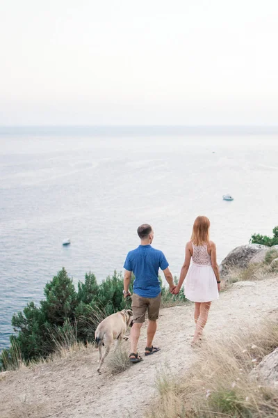 海の近くの山に自分の犬と遊ぶ男のカップル — ストック写真