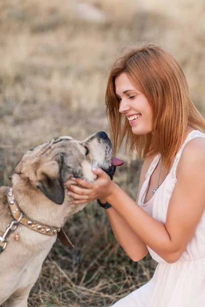 Jovem caucasiana caminhando com o cão durante o nascer do sol Imagem De Stock