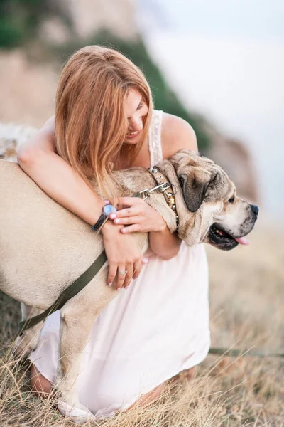 Jovem caucasiana caminhando com o cão durante o nascer do sol Fotografia De Stock