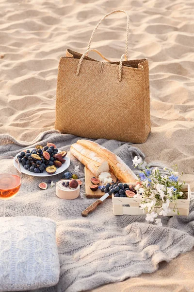 Piękny piknik z owoców i wina o zachodzie słońca w pobliżu morza — Zdjęcie stockowe