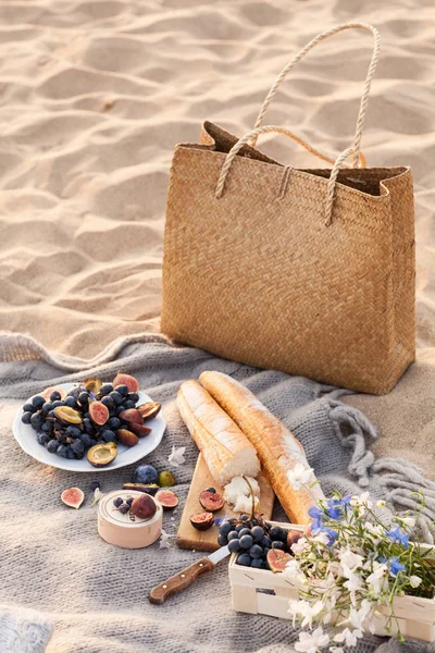 Piękny piknik z owoców i wina o zachodzie słońca w pobliżu morza — Zdjęcie stockowe