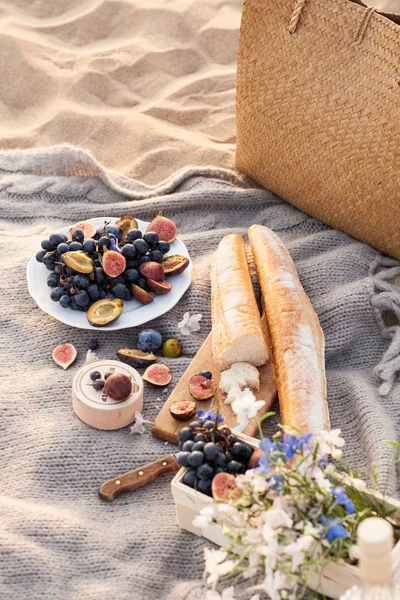 Un bellissimo picnic con frutta e vino al tramonto vicino al mare — Foto Stock