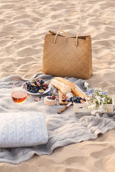 Гарний пікнік з фруктами і вином на заході сонця біля моря Стокове Зображення
