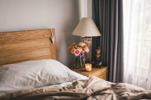Säng med vita lakan. Ett sängbord av sängen med en — Stockfoto