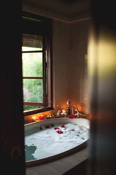 Duże wypełnione kąpiel z pianką i kwiaty. Romantyczna atmosfera, Bu — Zdjęcie stockowe