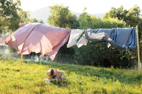 Sauberes Bettlaken hängt an Wäscheleine auf Frühling Natur. lizenzfreie Stockbilder