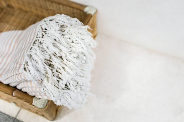 Toalhas de algodão listrado branco na cesta de vime contra a parede branca . — Fotografia de Stock
