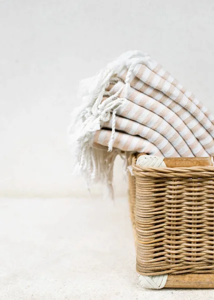 Toallas de algodón raya blanca en la cesta whicker contra la pared blanca . —  Fotos de Stock