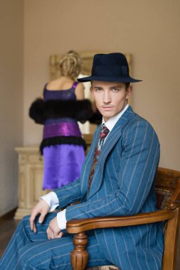 Kız kendini aynaya pansuman olduğunu ederken adam sandalyenin üstüne oturuyor