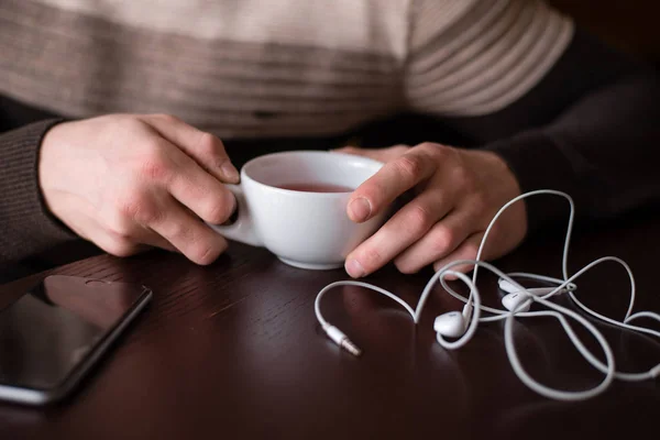 Csésze tea, a fülhallgató és a telefon — Stock Fotó