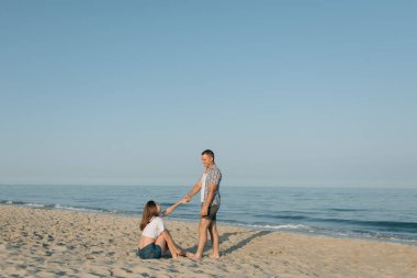 Sevgi dolu çift ellerini denize tutar.