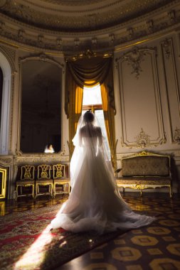 Gelin onun elinde bir buket ile pencerenin kenarında duruyor