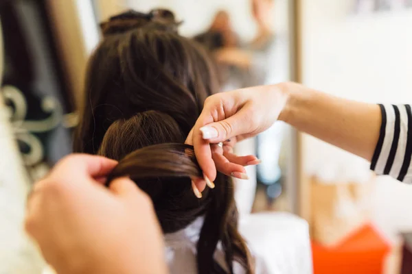 The hands of a hairdresser who makes a feminine hairdo — Stock Photo, Image