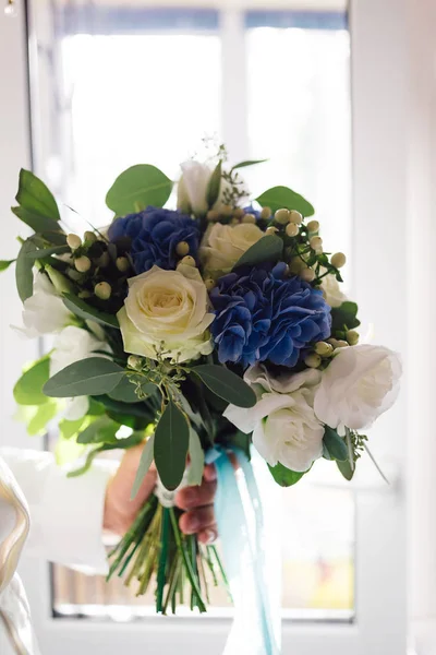 Svatební kytice růže, pivoněk a dalších květin je v rukou ženicha — Stock fotografie