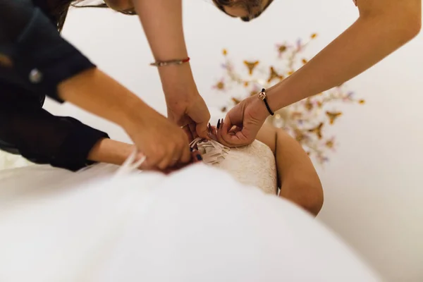 Parecchie coppie di mani femminili stringono il vestito della sposa — Foto Stock