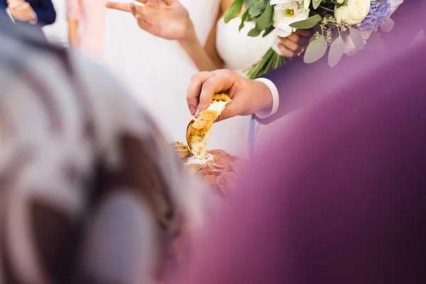 彼の手で保持している新郎結婚式パンの切れ端 — ストック写真