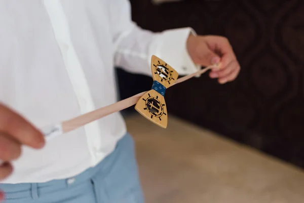 Les mains masculines du marié tiennent un papillon pour une bande élastique — Photo