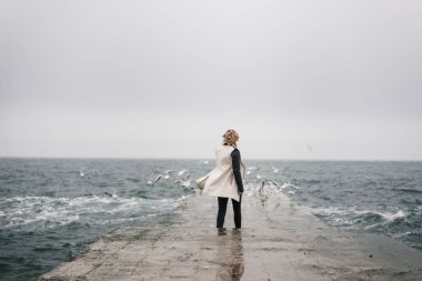 Genç bir öğrenci bir nemli iskelede yürüyüş ve bakar